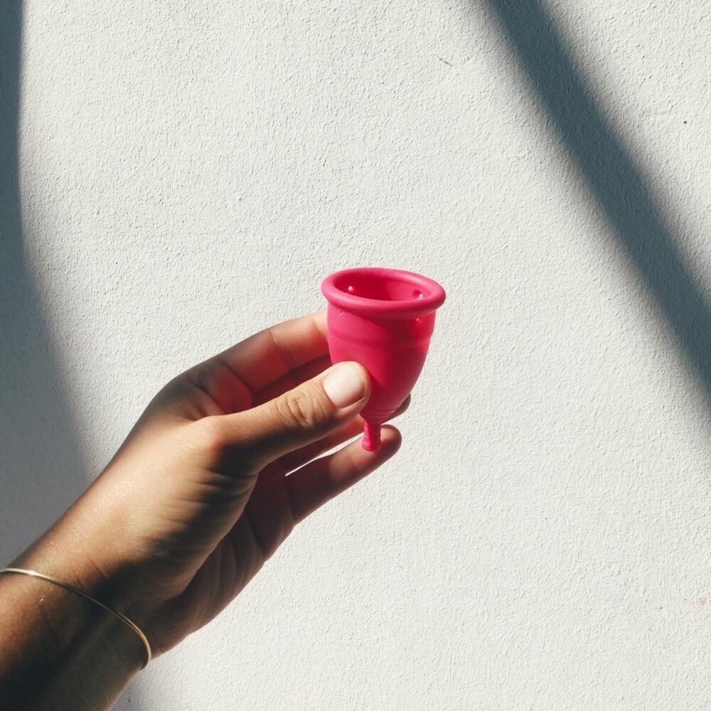 Hand holding TOTM menstrual cup