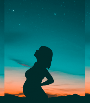 Shadow of a pregnant woman standing against the night sky