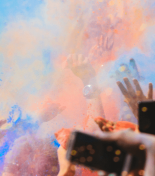 People dancing in colour powder during a festival