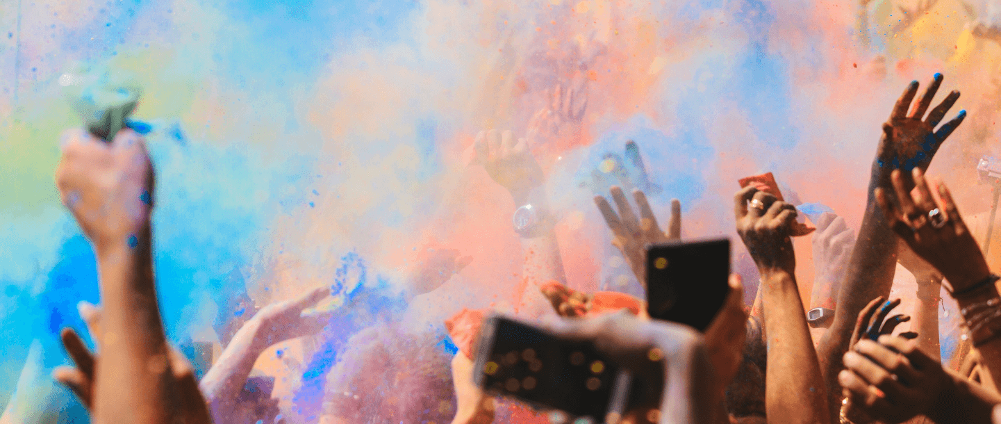 People dancing in colour powder during a festival