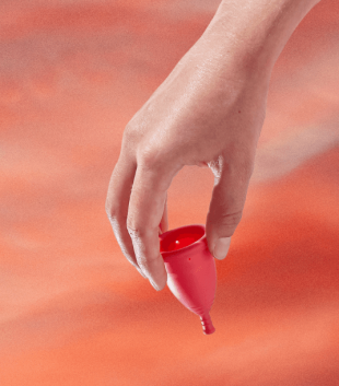 TOTM reusable zero waste menstrual cup on a red background